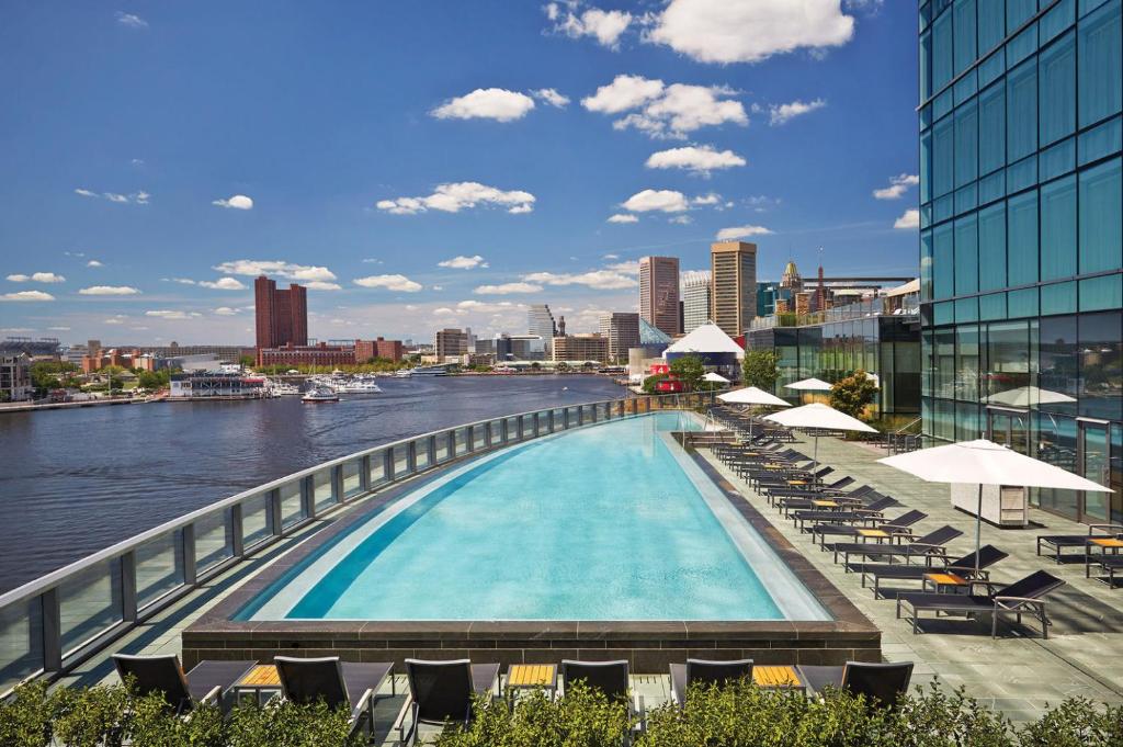 a swimming pool on top of a building next to a river at Four Seasons Baltimore in Baltimore