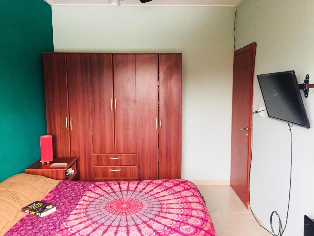Departamento-Casa-Marcos في لا بلاتا: غرفة نوم بسرير وخزانة خشبية