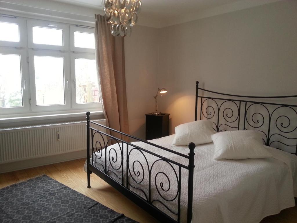 Schlafzimmer mit einem schwarzen Bett mit weißer Bettwäsche und Kissen in der Unterkunft Haus MeerZeit in Cuxhaven