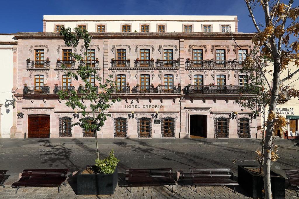 a large white building with benches in front of it at Emporio Zacatecas in Zacatecas