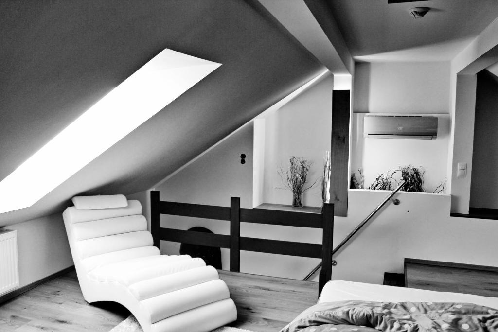 - une chambre mansardée avec un lit et une lucarne dans l'établissement Apartmány Ztracená, à Roudnice nad Labem