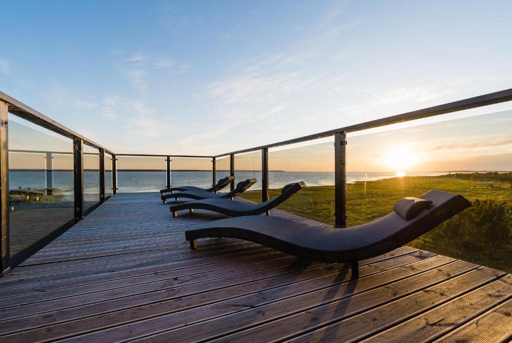 a wooden deck with a view of the ocean at Bottengarn Boutique Guesthouse in Koguva