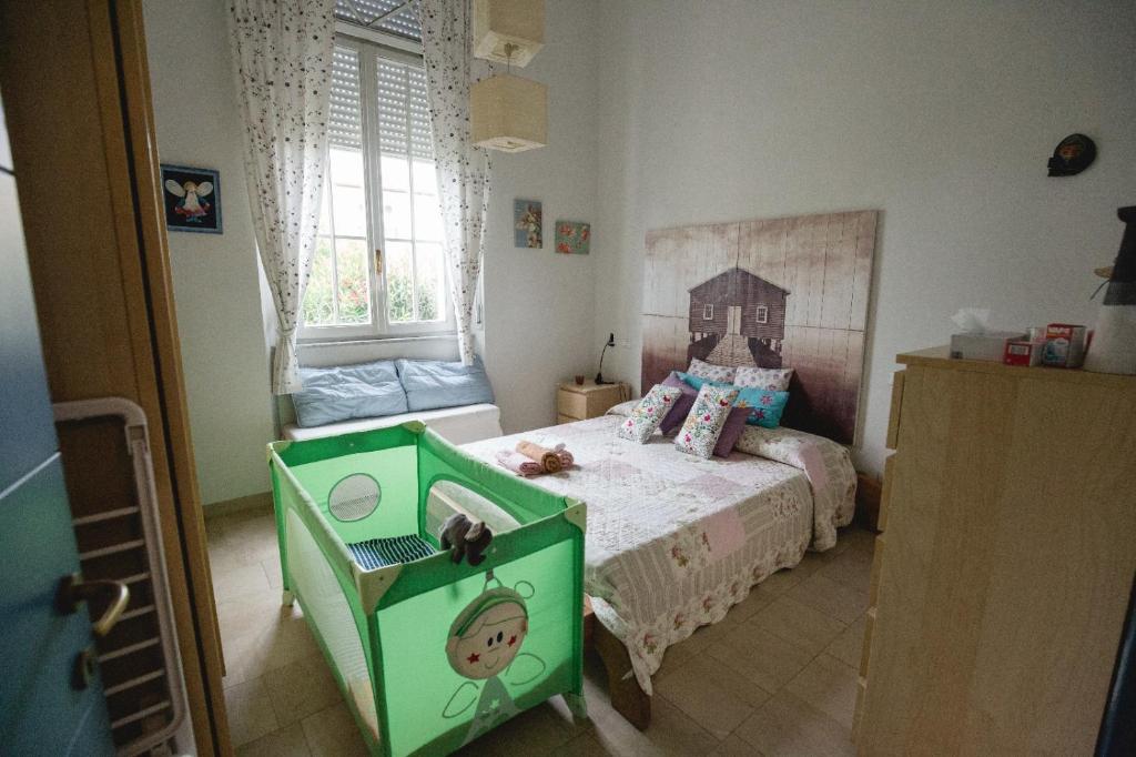 a childs bedroom with a green bed and a window at Sea beach relax in Tirrenia