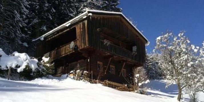 オーバーアウにあるZauberhuette Wildschoenauの雪の中の丸太小屋