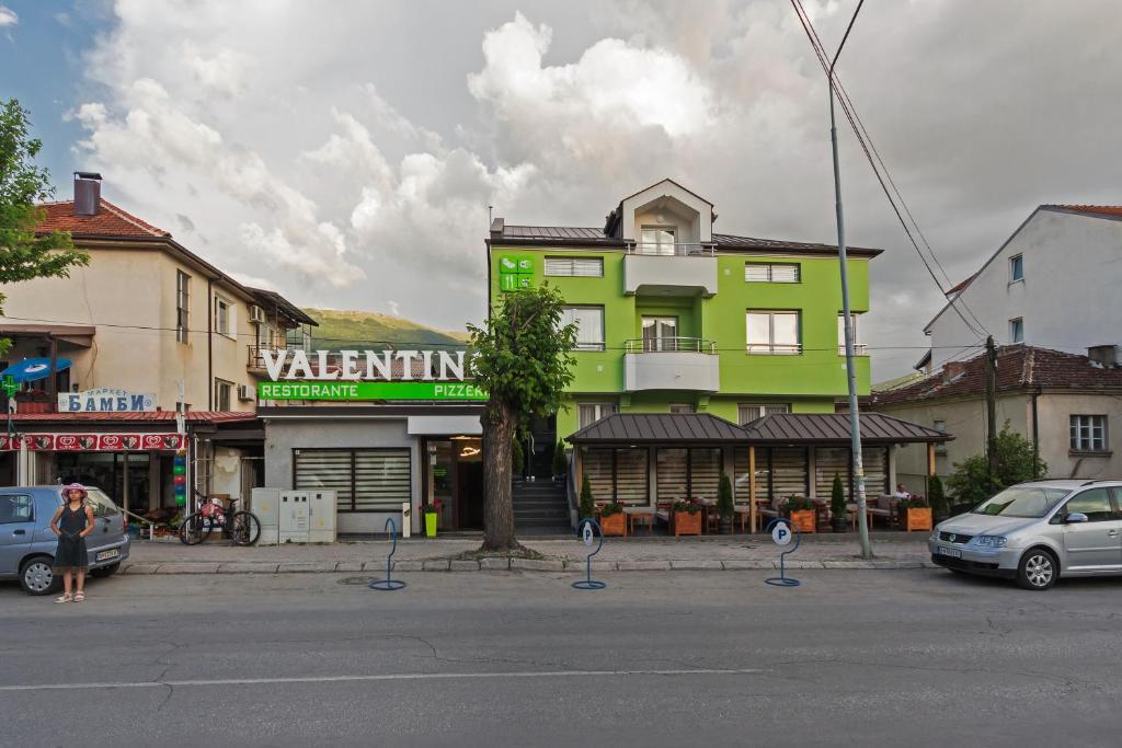 a yellow and green building on a city street at Apartments Valentino in Ohrid