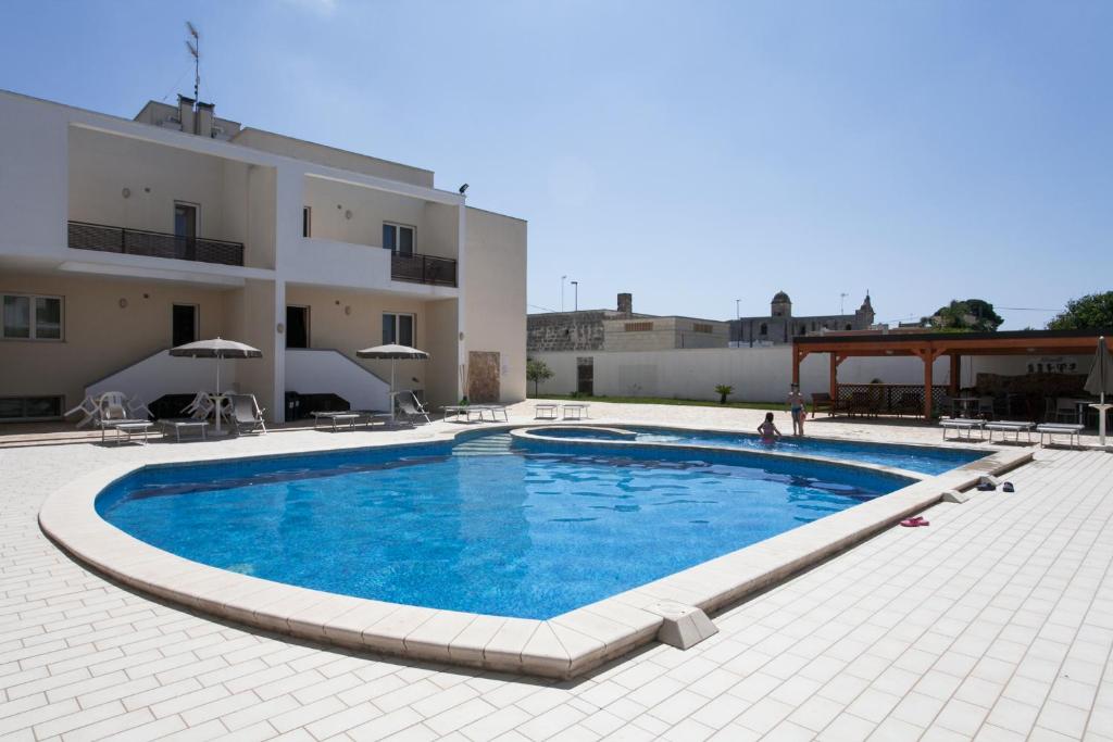 una grande piscina di fronte a un edificio di B&B Monelli a Diso