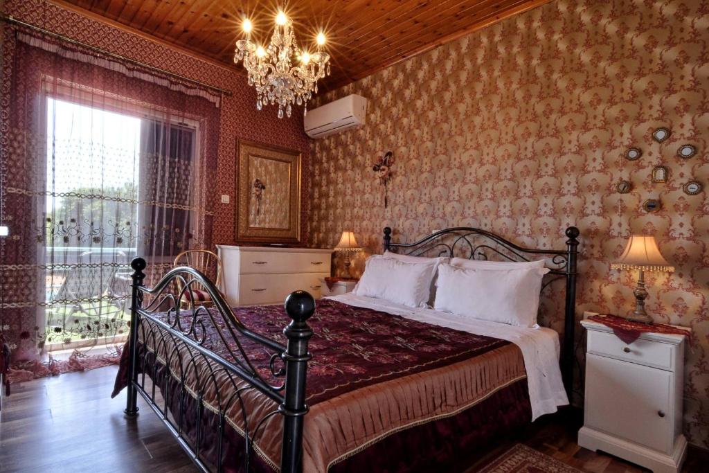 a bedroom with a bed and a chandelier at Pipitsa's Apartments in Roda