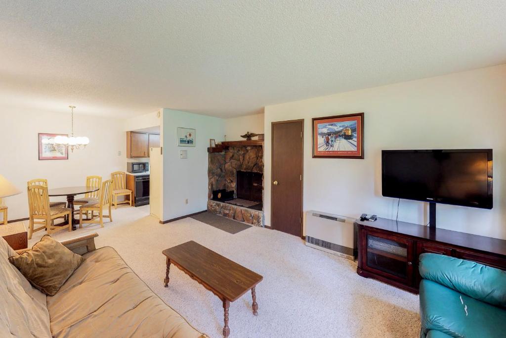 a living room with a couch and a flat screen tv at Skiview #103 in Girdwood