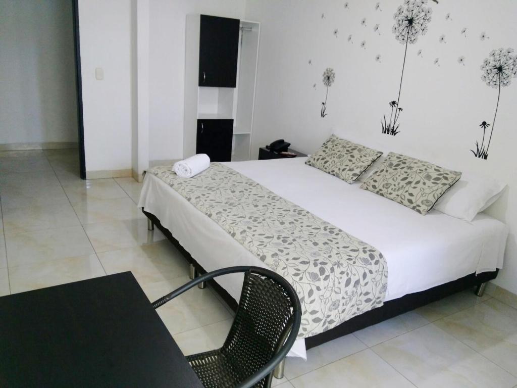 a bedroom with a bed and a table and a chair at Hotel Cosmos Sincelejo in Sincelejo
