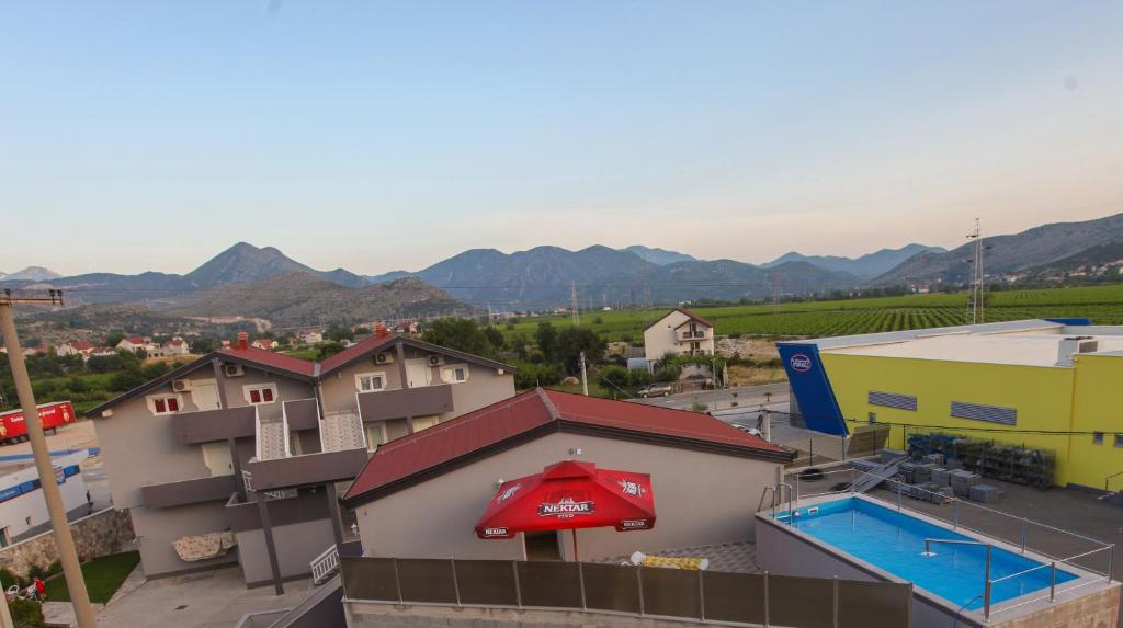 a view of a building with a swimming pool and mountains at Ninkovic in Trebinje