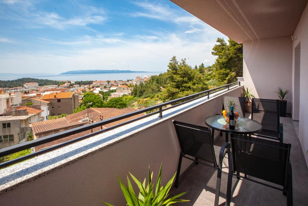 balcone con tavolo, sedie e vista di Apartments Bella Figura a Makarska