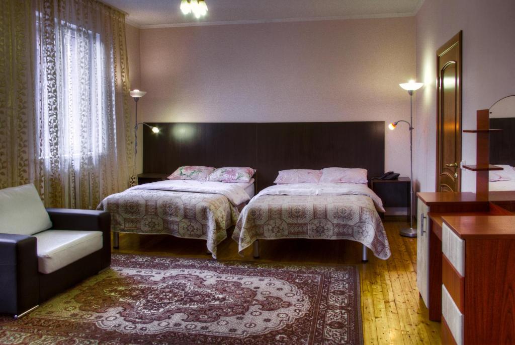 a hotel room with two beds and a couch at Guest House on Sadovaya in Almaty