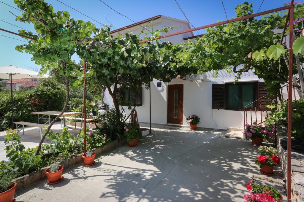 a house with a bunch of plants in front of it at Apartment Vitaic in Supetar