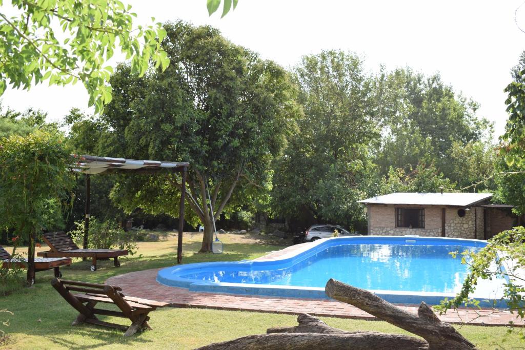 una piscina en un patio con una mesa y un banco en Cabanas Las Achiras en San Javier