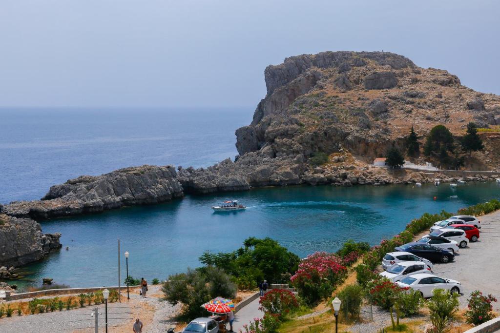a bunch of cars parked in a parking lot near the water at St. Paul's Bay View Suites in Lindos