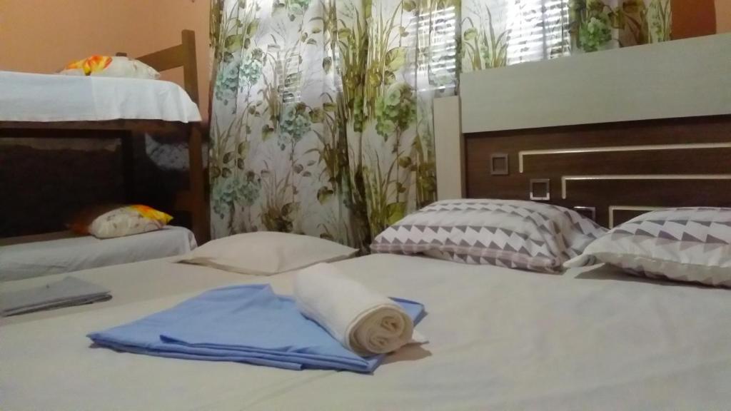 Una cama con dos almohadas y una toalla. en Praieiro Hostel Albergue, en Parnaíba
