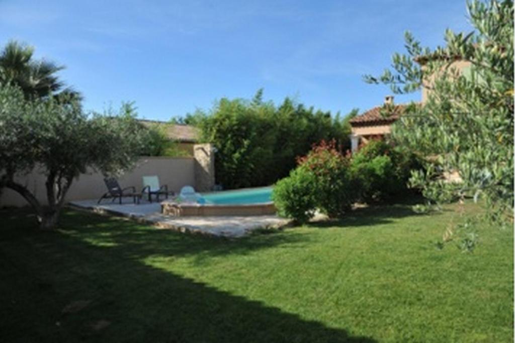 a yard with a swimming pool and a house at L'Olivette in Montagnac