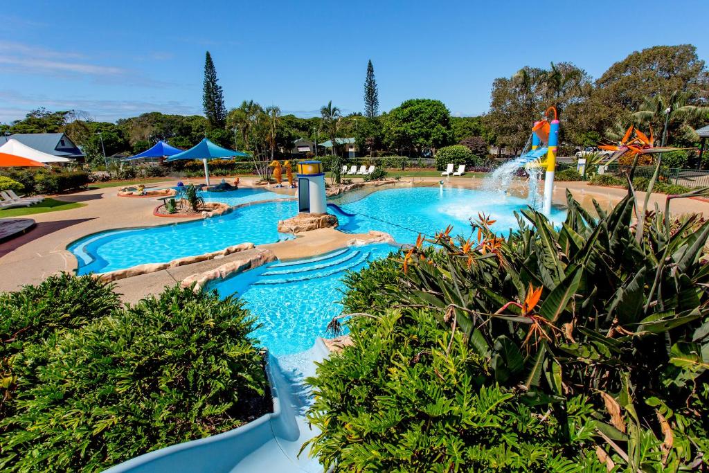 a pool at a water park with a water slide at BIG4 Park Beach Holiday Park in Coffs Harbour