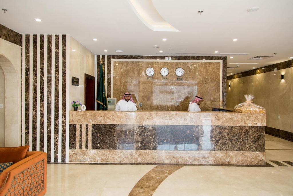 twee mannen aan een bar in een hotellobby bij Farha International Residential Units in Jeddah