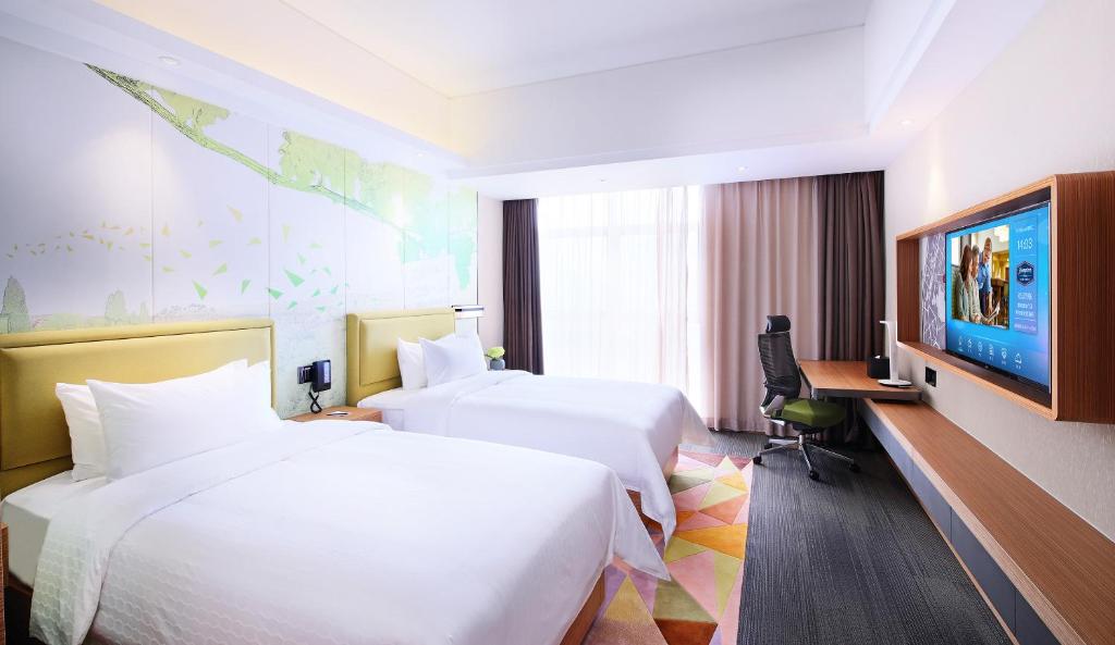 Postel nebo postele na pokoji v ubytování Hampton by Hilton Zhuhai Cheng Feng Plaza