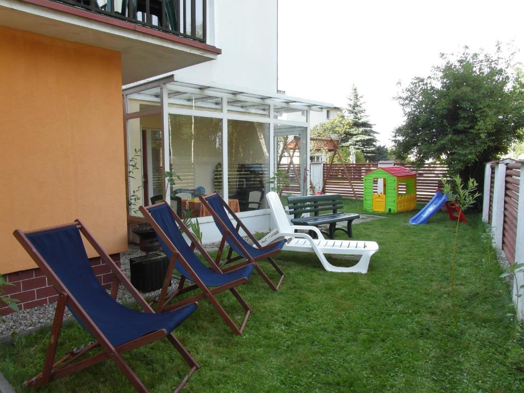 un grupo de sillas y un parque infantil en un patio en Villa Banita, en Ustka