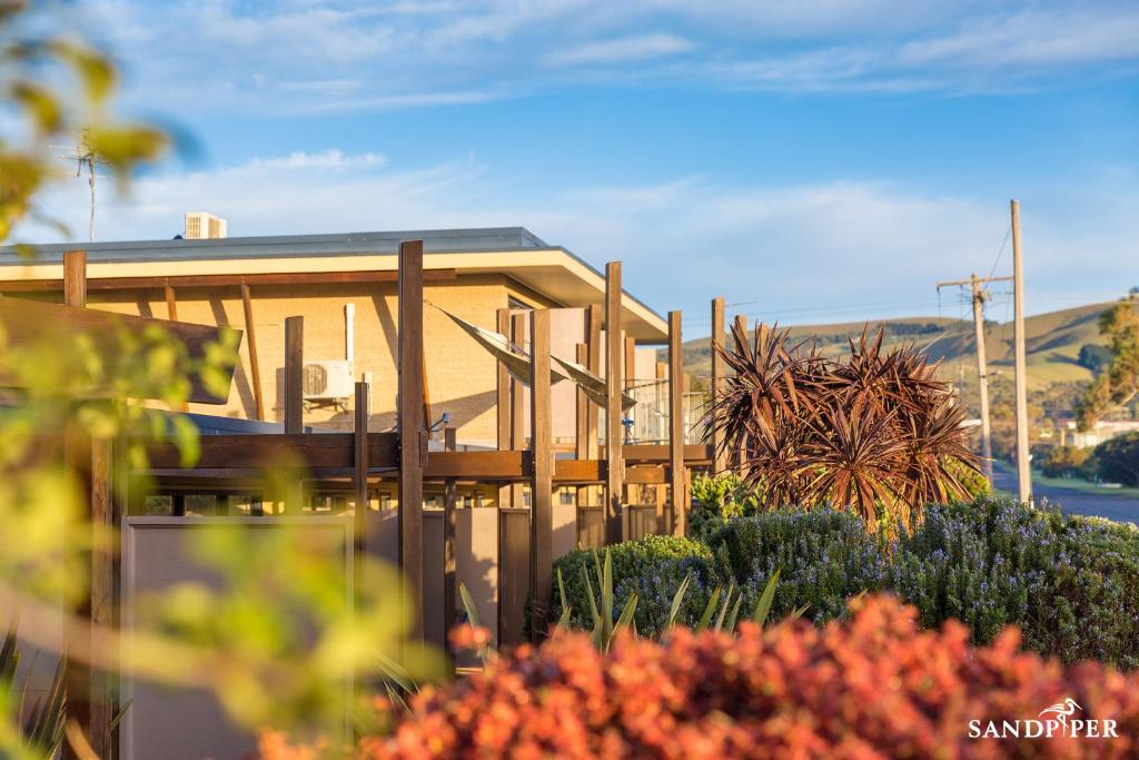 Sandpiper Motel Apollo Bay في خليج أبولو: منزل امامه سياج ونباتات