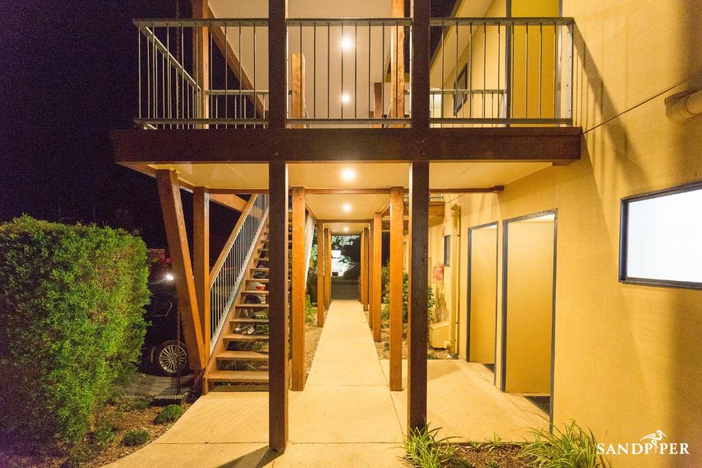 a hallway leading to a building with a balcony at Sandpiper Motel Apollo Bay in Apollo Bay