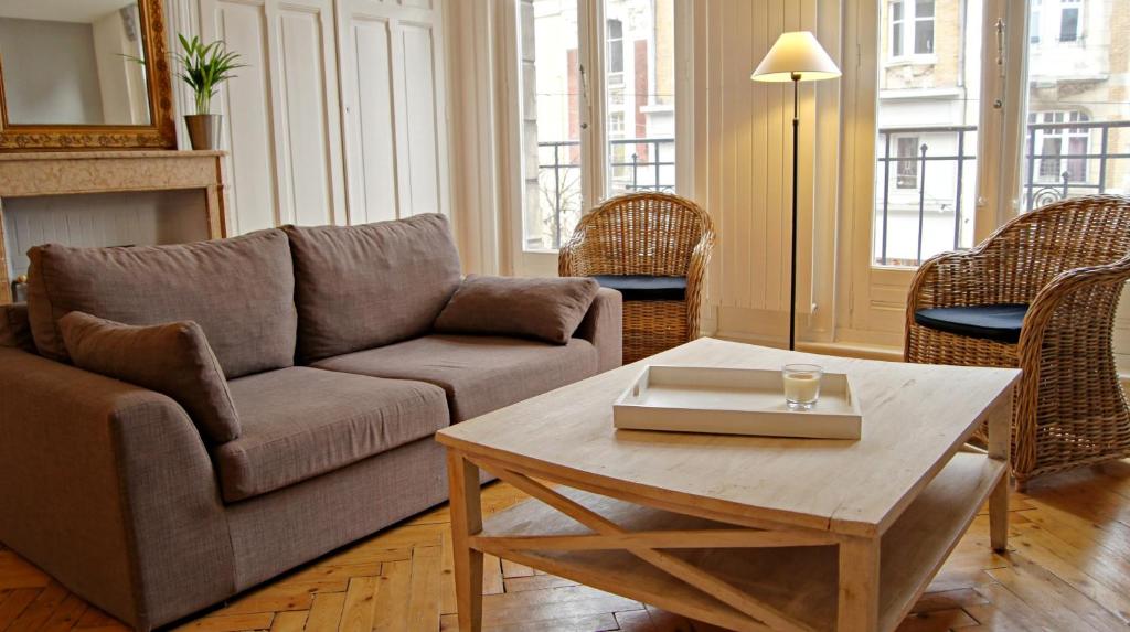 ein Wohnzimmer mit einem Sofa und einem Couchtisch in der Unterkunft Little Suite - Antonin in Lille