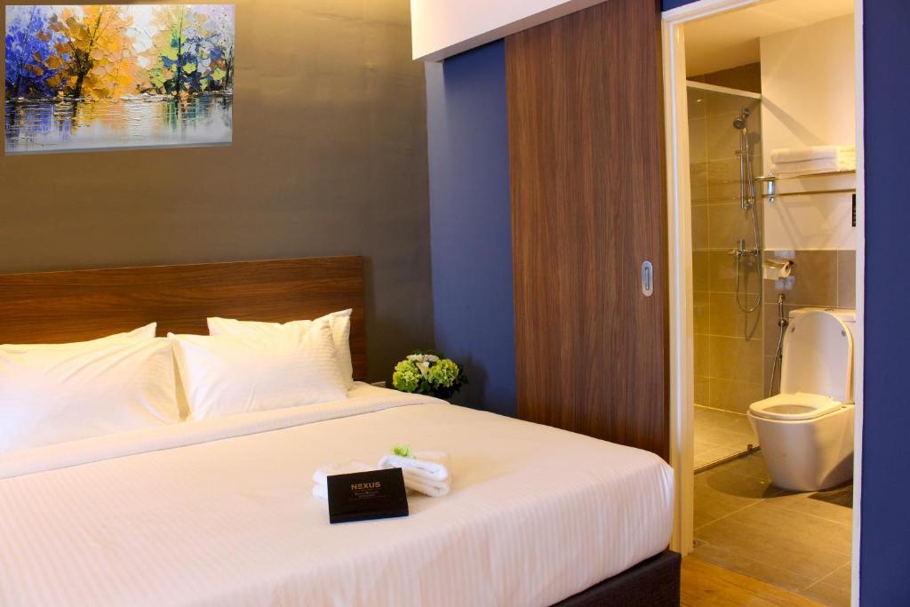 A bedroom with a made bed and a visible bathroom doorway.