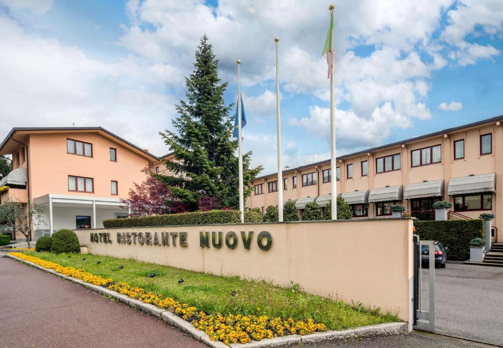 a building with the sign for the executive moxy at Best Western Hotel Nuovo in Garlate