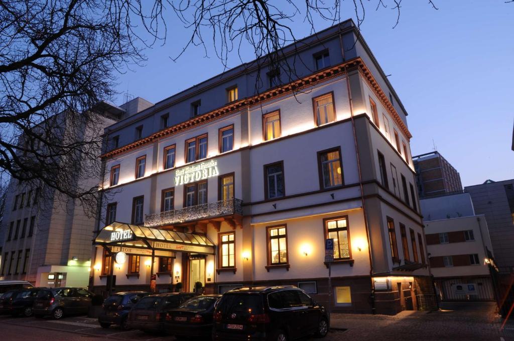 um grande edifício com luzes acesas numa cidade em Best Western Premier Hotel Victoria em Friburgo em Brisgóvia
