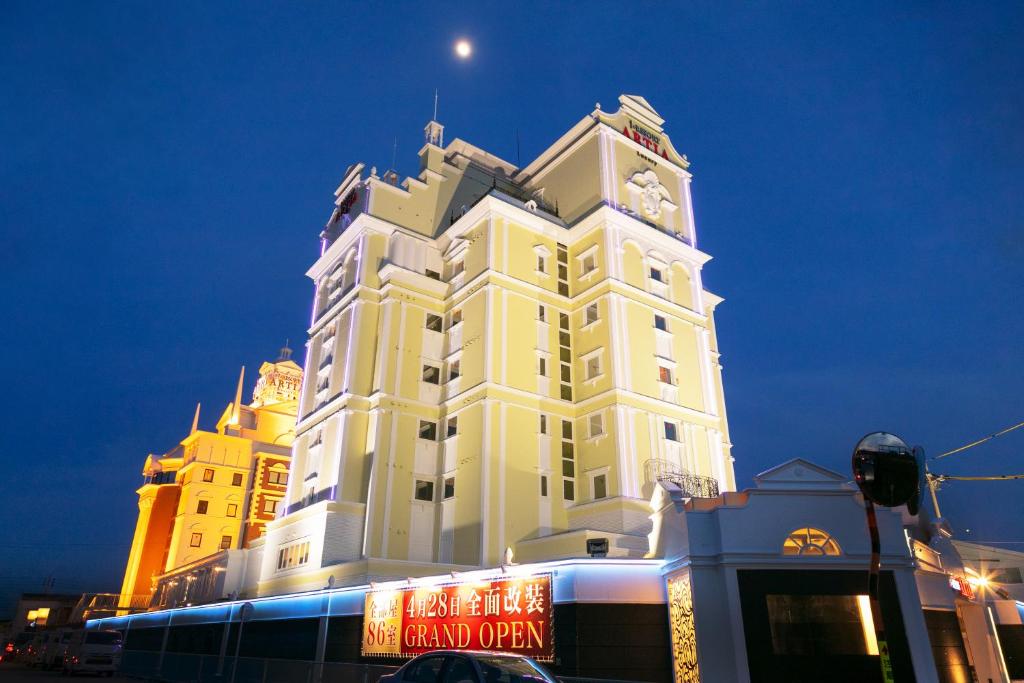 a large white building with a clock tower at night at i RESORT ARTIA Luxury Gifu (Adult Only) in Gifu