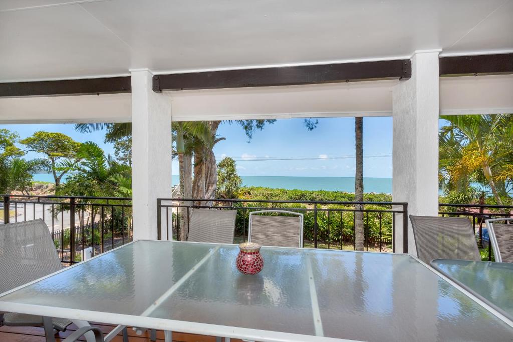 una mesa en un balcón con vistas al océano en Dolce Vita en Clifton Beach