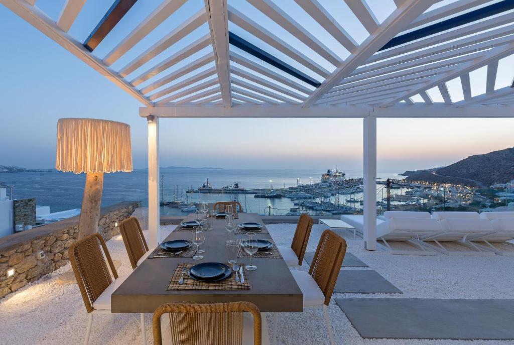 a dining table on a patio with a view of the ocean at Sealine Villas in Tourlos