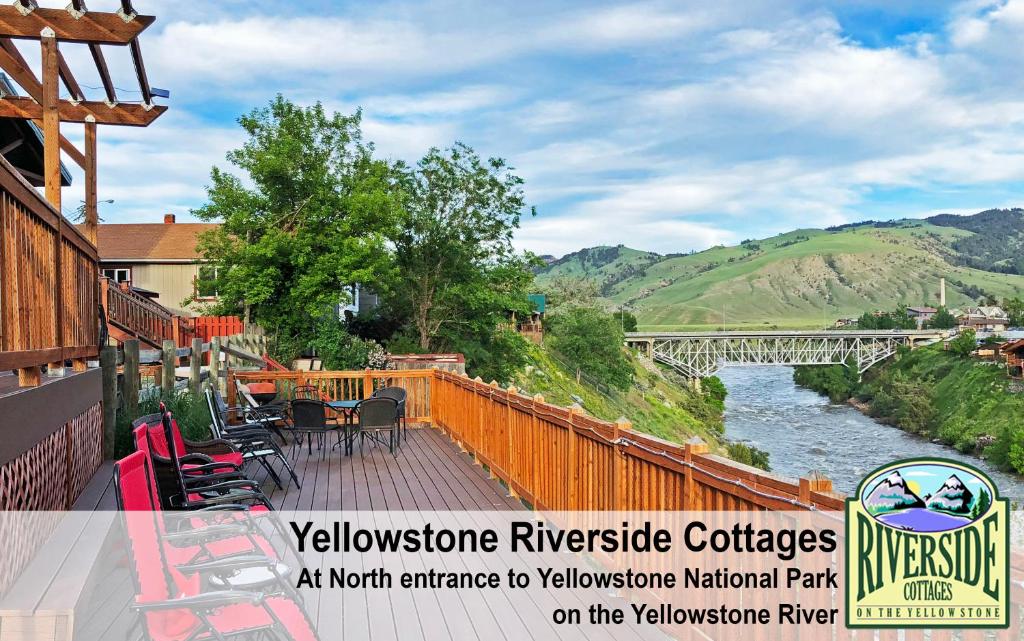 an outdoor deck with a view of a river at Yellowstone Riverside Cottages in Gardiner