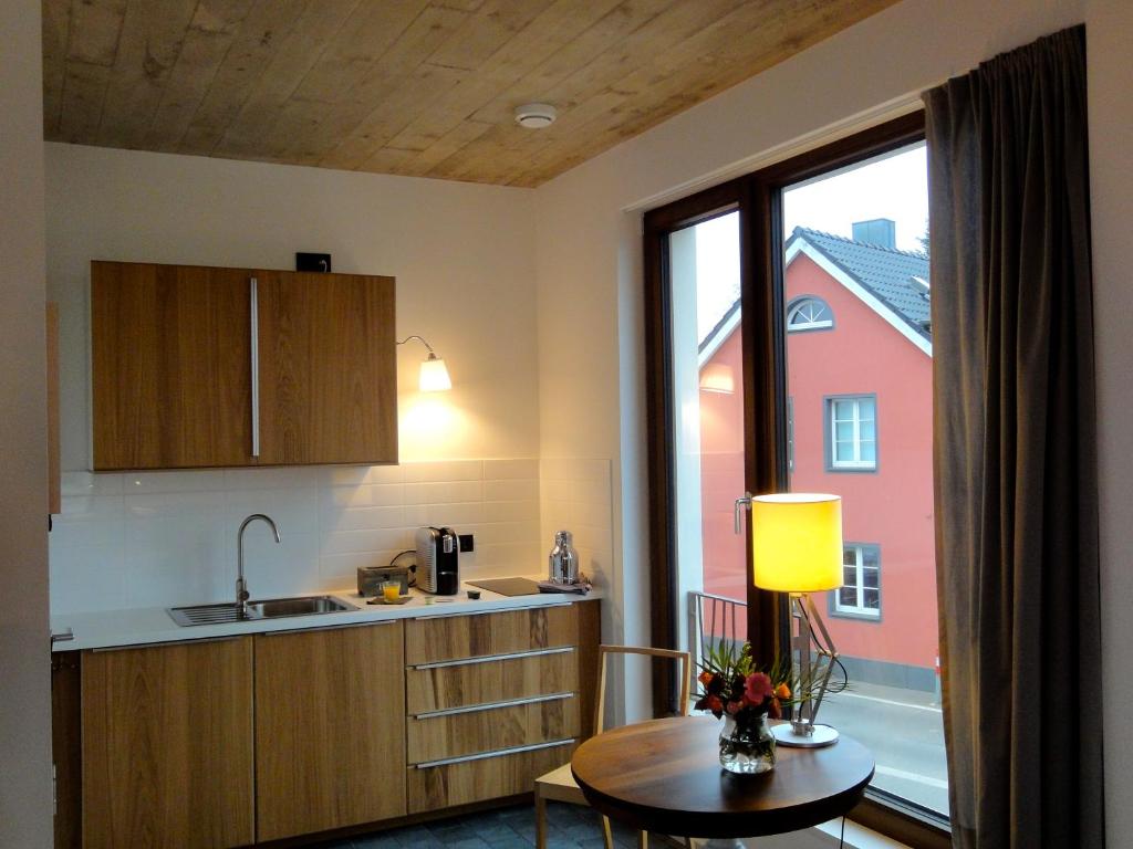 una cucina con lavandino, tavolo e finestra di Cologne Country Lodge a Colonia