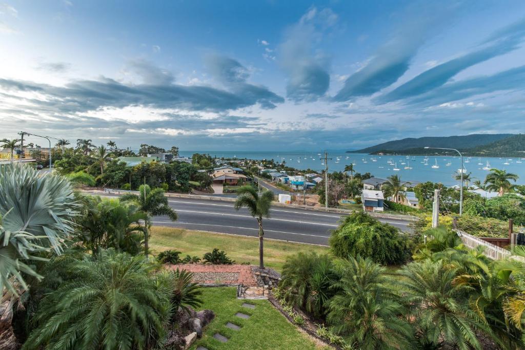 a view of a street with palm trees and the ocean at Hayman Views in Airlie Beach