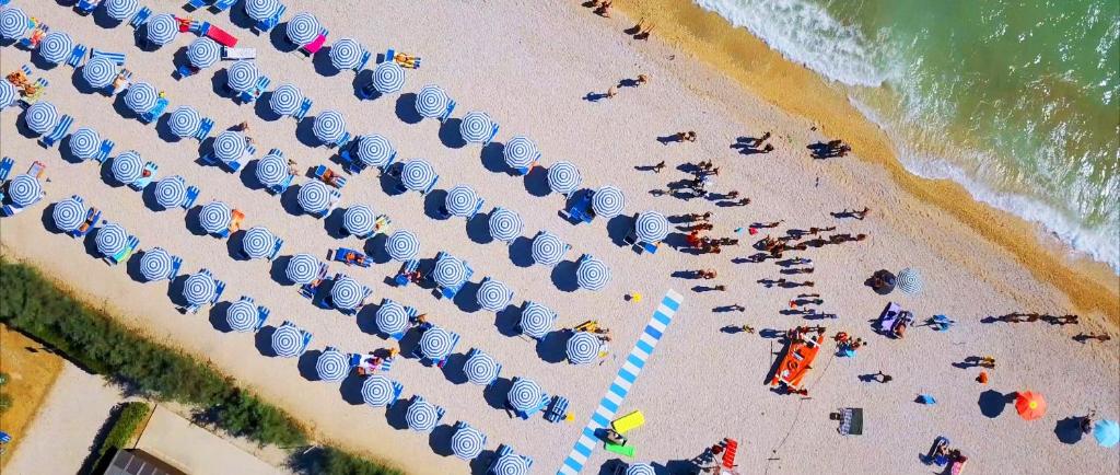 an overhead view of a crowded beach with umbrellas at Villaggio Turistico Le Mimose in Porto SantʼElpidio