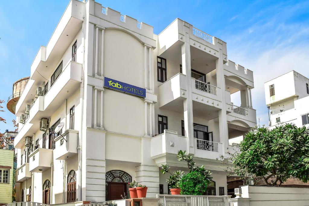 un bâtiment blanc avec un panneau bleu dans l'établissement FabHotel Jaipur Villa, à Jaipur