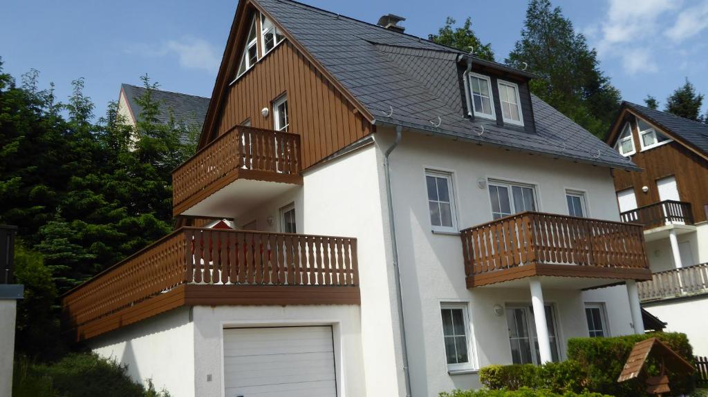 クアオルト・オーバーヴィーゼンタールにあるHaus am Berg - großes Haus mit Sauna für bis zu 10 Personen unweit vom Skihangの白い家(木製バルコニー付)