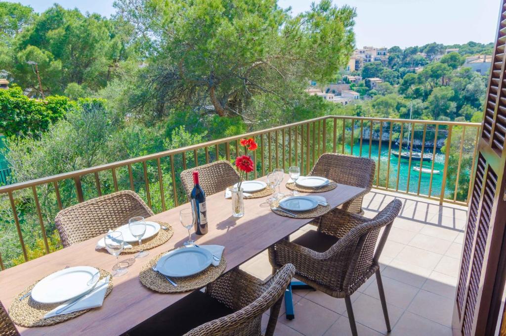 a wooden table and chairs on a balcony with a view at Cala Figuera in Cala Figuera