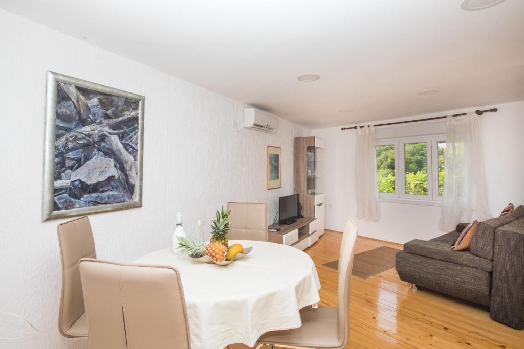 uma sala de estar com uma mesa e um sofá em Madonna Field Apartment em Dubrovnik