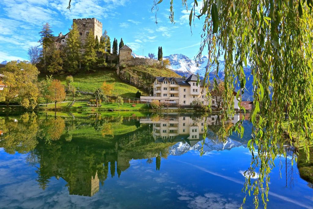 a castle sitting on top of a hill next to a lake at Seeapart Pöder in Ladis