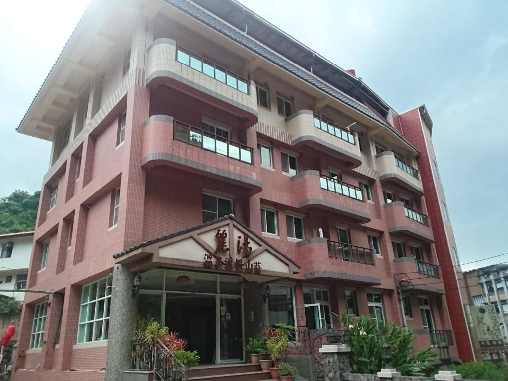 a large pink building with a balcony at Li Tang in Baihe