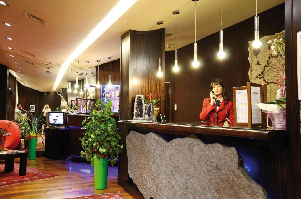 une femme debout dans un bar avec un microphone dans l'établissement Hotel La Fenice, à Belpasso