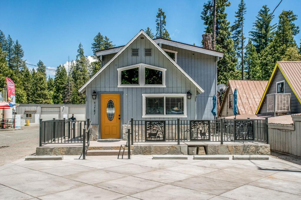 a gray house with a orange door and a fence at The Villager in Shaver Lake