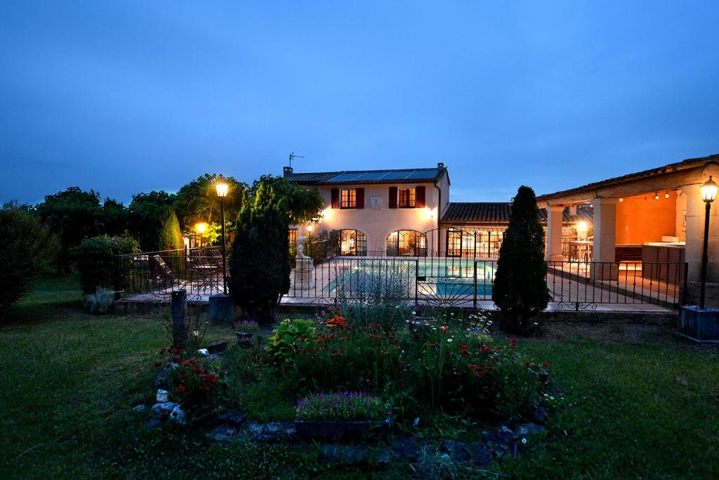 ein Haus mit einem Zaun und einem Garten in der Nacht in der Unterkunft Bastide Les Basses Royères in Robion en Luberon