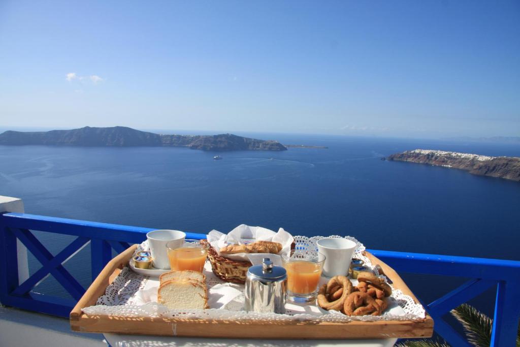a tray of food on a table with a view of the ocean at Prekas Apartments in Imerovigli