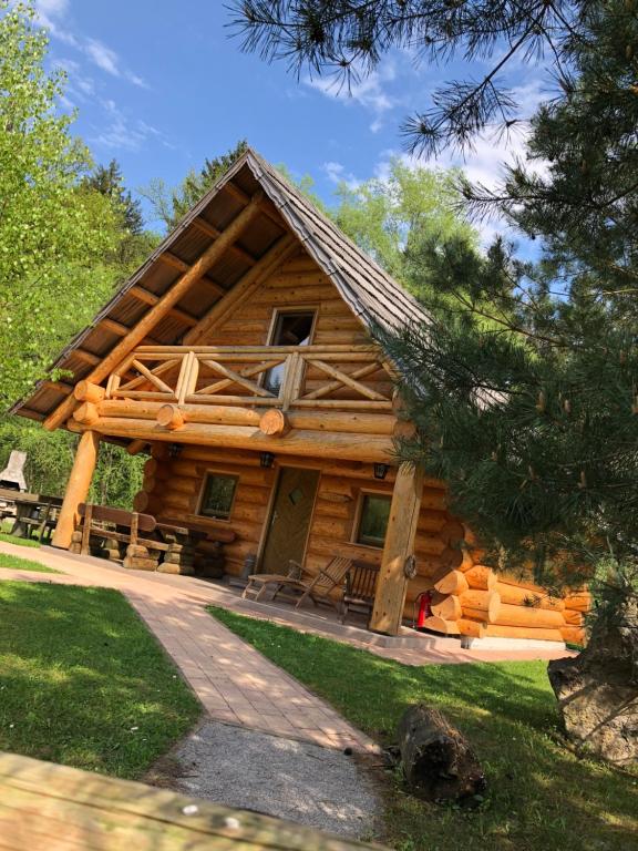 a log cabin with a porch and a window at Korošec Apartments and Wellness Centre in Mozirje