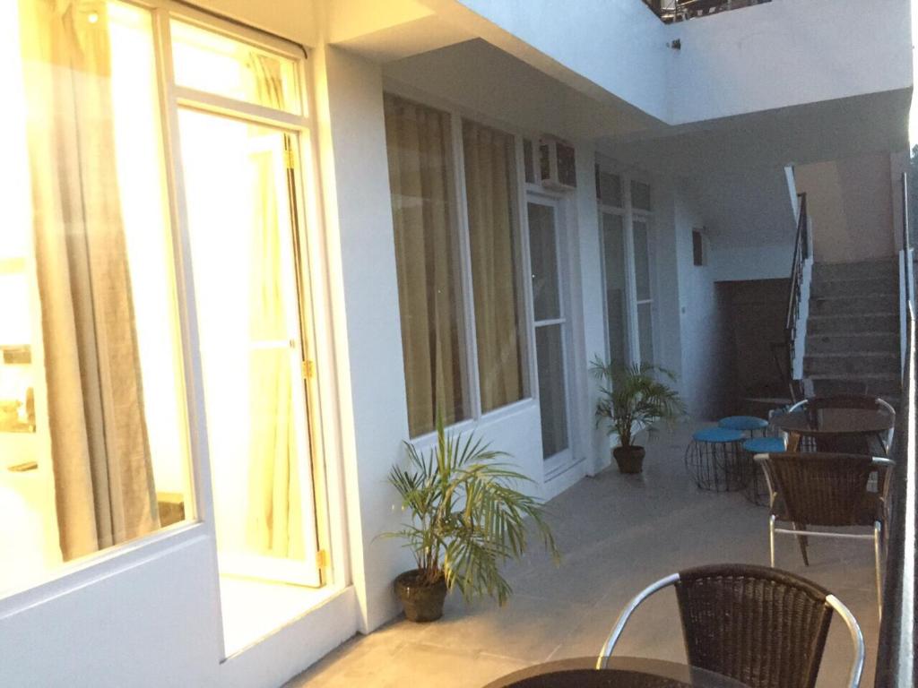 a room with chairs and a balcony with windows at Alta Residences in Daraga